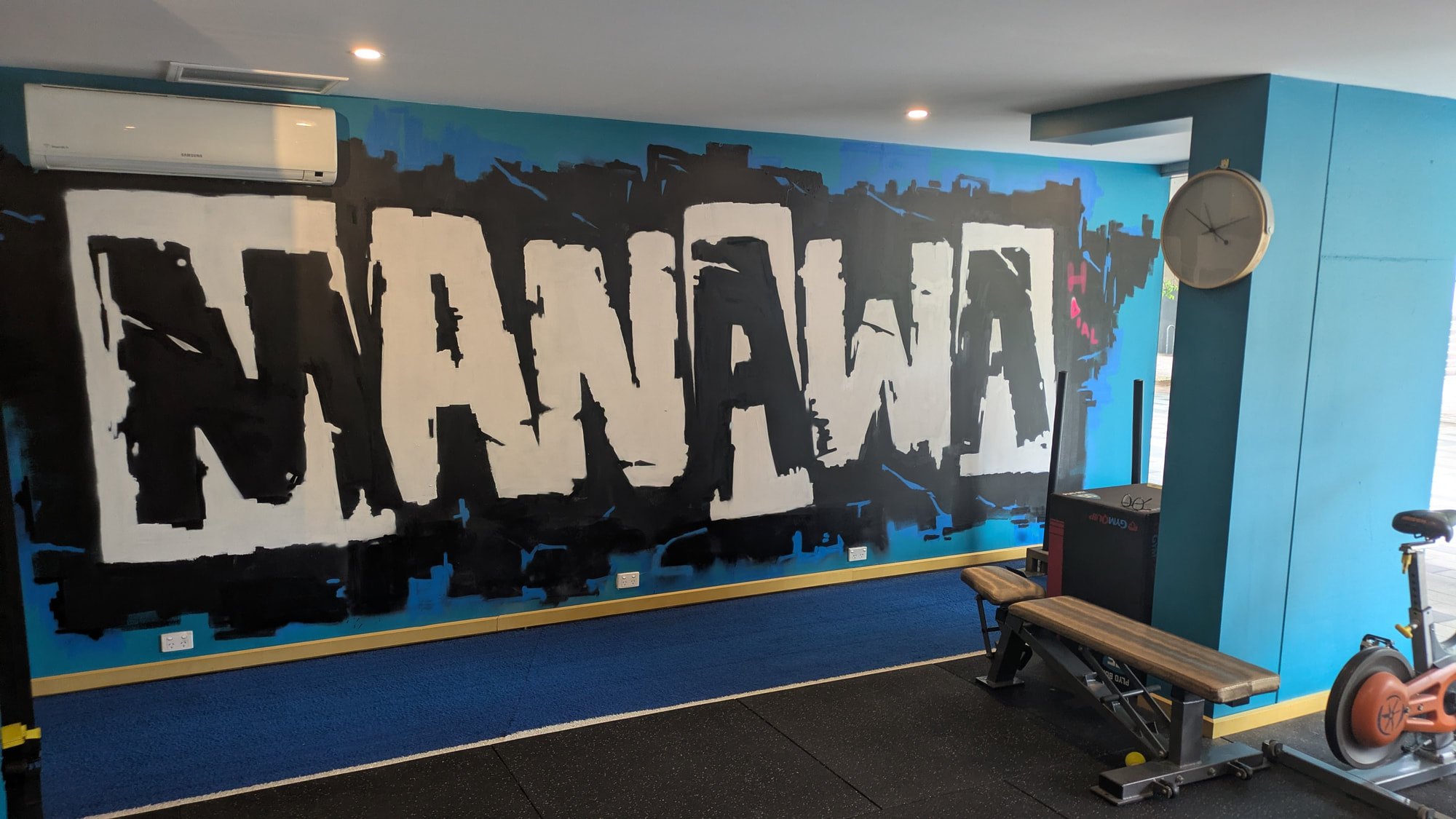 The studio's Manawa mural wall with a bench and exercise bike